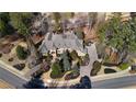 Luxury home boasts an impeccably manicured lawn, mature trees, and a circular driveway at 939 Middle Fork Trl, Suwanee, GA 30024