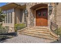 Stately stone entrance with wooden door, stone steps, iron railings and manicured landscaping at 939 Middle Fork Trl, Suwanee, GA 30024