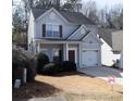 Charming two-story home with gray siding, dark shutters, and an attached one car garage at 235 Woodland Way, Canton, GA 30114