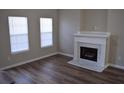 Bright living room featuring wood floors, a fireplace with marble hearth, and two windows at 235 Woodland Way, Canton, GA 30114