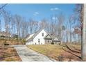 New home with three car garage, stone accents, and a long driveway nestled among mature trees at 40 Oak Forest Dr, Oxford, GA 30054