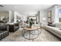 Bright living room featuring modern furnishings, an eye-catching rug, and seamless flow into the adjacent kitchen and dining area at 205 Delilah St, Mcdonough, GA 30252