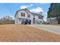 Two-story home with vinyl siding, red shutters, attached garage, and a long driveway at 210 Meadow View Dr, Grayson, GA 30017