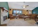 Cozy living room with stone fireplace, plush seating, and a ceiling fan at 210 Meadow View Dr, Grayson, GA 30017