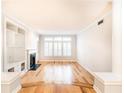 Bright living room with hardwood floors, fireplace, built-in shelving, and large windows with shutters at 220 Renaissance Ne Pkwy # 1105, Atlanta, GA 30308