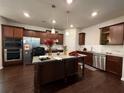 Well-lit kitchen featuring stainless steel appliances, dark wood cabinets, granite countertops, and a center island at 3208 Baylor Cir, Mcdonough, GA 30253