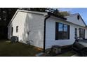 A corner view of the house with white siding and black window trim on a sunny day at 4778 Pebble Trce, Buford, GA 30518