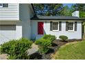 Close-up of a freshly painted home featuring a bright red front door and black shutters at 2157 Tiffany Ln, Lithonia, GA 30058