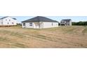 A home's exterior back view shows a large yard and white siding at 8599 Secretariat Dr, Lithonia, GA 30058