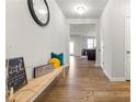 Inviting hallway featuring wood floors, a decorative bench, and a view into the living area at 4779 Mock Orange Sw St, Atlanta, GA 30331