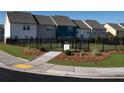 Rear view of townhomes featuring fenced yards and landscaping at 1115 Lockhart Way, Douglasville, GA 30135