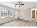Bright, carpeted bedroom with a ceiling fan and a large window at 3552 Meadowview Dr, Lithia Springs, GA 30122