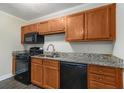 Cozy kitchen featuring granite counters, wood cabinets, and black appliances at 3552 Meadowview Dr, Lithia Springs, GA 30122