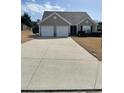 A charming single story home features a two-car garage and well-manicured lawn at 4644 Pine Isle Way, Sugar Hill, GA 30518