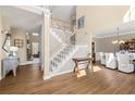 Bright foyer features hardwood floors, staircase leading to the second floor, and views into living spaces at 5945 Masters Club Dr, Suwanee, GA 30024