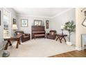 Cozy living room with two leather chairs, piano, and decoratively placed lamps and plants at 5945 Masters Club Dr, Suwanee, GA 30024
