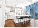 Modern white kitchen with stainless steel appliances, center island, and city view at 1065 Peachtree Ne St # 3105, Atlanta, GA 30309