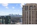 Picturesque skyline view showcasing modern high-rise buildings against a blue sky with fluffy clouds at 3475 Oak Valley Ne Rd # 410, Atlanta, GA 30326