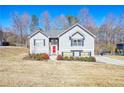 Charming two-story home featuring gray siding, dark shutters, a red front door, and landscaping at 4046 Harvest Ridge Dr, Douglasville, GA 30135