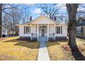 Inviting single-story home with a manicured lawn, a covered front porch, and classic architectural details at 34 N Broad N St, Porterdale, GA 30014