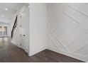 Bright entryway with hardwood floors, decorative wall paneling, and stairway access at 262 Green Hill Ne Rd, Sandy Springs, GA 30342