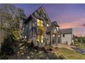 Stunning exterior elevation of a modern home with gray paint, a well-manicured lawn, and professional landscaping at 262 Green Hill Ne Rd, Sandy Springs, GA 30342