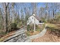 Exterior angle view of a cozy home nestled among trees, highlighted by a long driveway at 3870 Wyntuck Nw Ct, Kennesaw, GA 30152