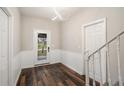 Bright entryway features wood floors, beadboard detail, modern light fixture and staircase access at 6219 Heardsville Rd, Cumming, GA 30028