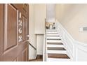Inviting entryway featuring wood stairs, trim, and a view into the adjacent living space at 1262 Park Pass Row, Suwanee, GA 30024