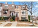 Two-story townhouse showcasing tan siding, contrasting shutters, and a charming brick staircase to the front entrance at 1262 Park Pass Row, Suwanee, GA 30024