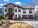 Charming two-story home with stone accents, a well-manicured lawn, and a two-car garage at 1352 Middlesex Ne Ave, Atlanta, GA 30306
