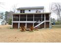 Enjoy the spacious backyard featuring a screened porch, stairs, and a charming seating area with wooden chairs at 4040 Merritt Dr, Cumming, GA 30041