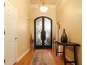 Elegant foyer featuring hardwood floors, a decorative rug, and a ornate ironwork door at 2250 Snug Ne Hbr, Marietta, GA 30066