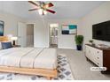 Serene main bedroom featuring a king bed, a ceiling fan, and a view into the main bathroom at 3153 Kingswood Gln, Decatur, GA 30034