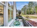 Cozy porch with wrought iron railing and space for an outdoor table and chairs, overlooking the lawn at 3580 S Sherwood Se Rd, Smyrna, GA 30082