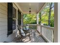 Relaxing front porch with rocking chairs, brick flooring, and a peaceful view of the surrounding trees at 1416 Elgin Way, Cumming, GA 30041