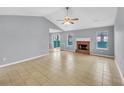 Bright living room with fireplace, vaulted ceiling, tile flooring, and sliding door to backyard at 1681 Graystone Dr, Hampton, GA 30228