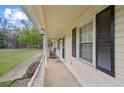 Covered porch with black shutters, offering a cozy outdoor seating area at 140 Wyonia Way, Fayetteville, GA 30215