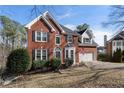 Lovely two-story brick home with an attached garage, manicured shrubs, and an American flag at 2447 Tift Nw Ct, Kennesaw, GA 30152