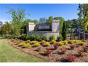 Well-maintained community entrance featuring brick signage, manicured landscaping, and lush greenery at 133 Ward'S Crossing Way # 18, Johns Creek, GA 30022