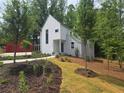 Beautiful modern home with lush landscaping, complemented by a red garage at 145 Cedarwood Ln, Roswell, GA 30075