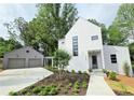 Beautiful modern home with white exterior, tidy landscaping, and a two-car detached garage at 145 Cedarwood Ln, Roswell, GA 30075