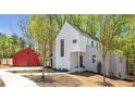 Stylish modern home showcasing a white exterior, red garage, and landscaped yard at 145 Cedarwood Ln, Roswell, GA 30075