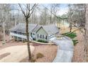 Angle view of the exterior displaying the garage, driveway, and surrounding natural wooded landscape at 1980 Two Springs Way, Lawrenceville, GA 30043
