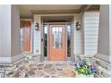 Elegant front entry with a stone porch, stylish door with sidelights, and decorative lantern-style lighting at 2964 Perimeter Cir, Buford, GA 30519