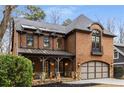 Beautiful brick home features a covered front porch with stone accents and an arched window above the garage at 2871 Parkridge Ne Dr, Brookhaven, GA 30319