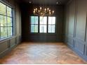 Elegant room with dark walls, decorative mouldings, beautiful wood floors, and natural light from large windows at 1366 Wessyngton Ne Rd, Atlanta, GA 30306