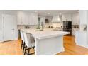 Bright kitchen featuring a large center island with seating, white cabinetry, and hardwood floors at 118 Fairway Overlook Dr, Acworth, GA 30101