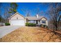 Single-story home with a two-car garage, nestled on a wooded lot at 185 Whetstone Way, Villa Rica, GA 30180