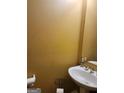 Powder room featuring a pedestal sink, gold faucet, and decorative mirror at 3551 Northgate Cv, Ellenwood, GA 30294